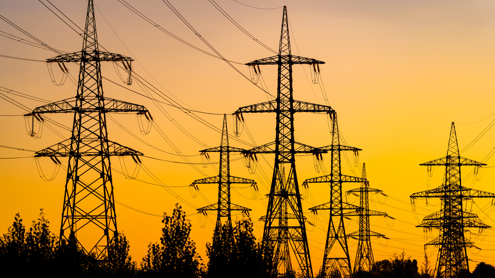 Zachód linii przesyłowej nad głową: pomarańczowy blask elektryczny